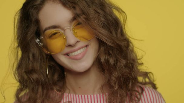 Young woman smiling on yellow background. Portrait of happy girl smiling - Photo, Image