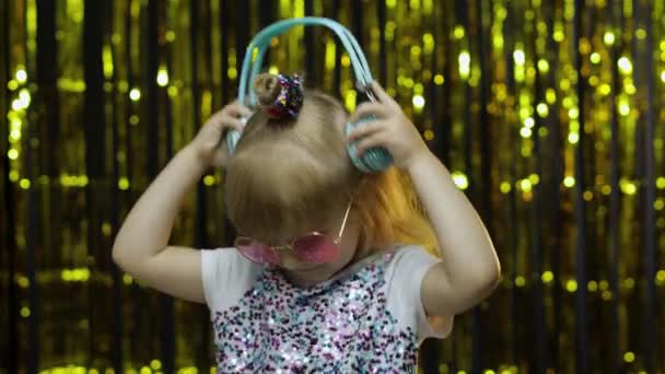 Gyerek táncol, zenét hallgat fejhallgatón. Gyerek lány tánc, miután hun, pihentető, élvezi - Felvétel, videó