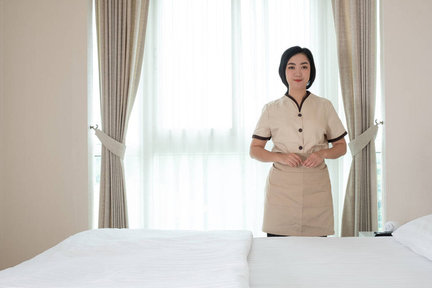 Joven criada de Asia en la habitación de hotel su mirada a la cámara - Foto, Imagen