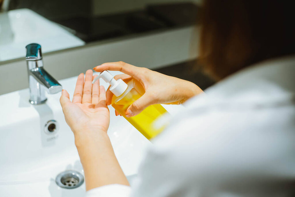 Weibchen verwenden Alkohol antiseptisches Gel zur Reinigung der Hand - Foto, Bild