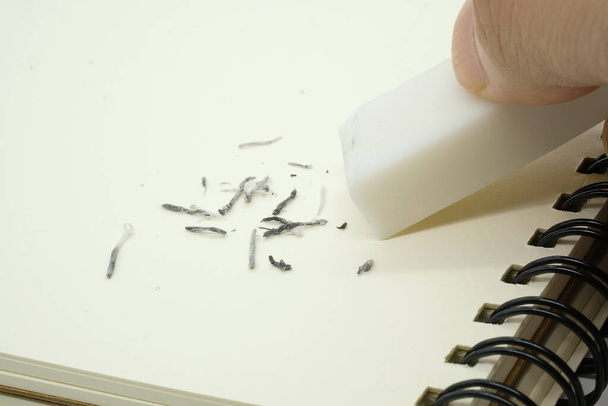 eraser removing a written mistake on a piece of paper. - Photo, Image