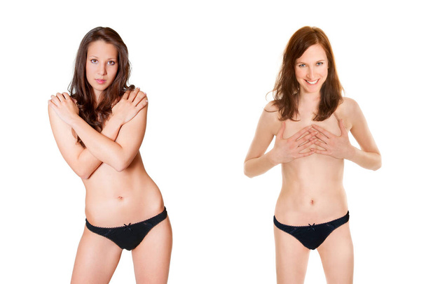 Dos mujeres en topless vistiendo bragas negras y escondiendo sus pechos, aisladas frente al fondo blanco del estudio - Foto, imagen