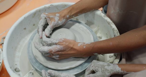 陶器の車輪の上に陶器の鍋を作るポッター  - 写真・画像