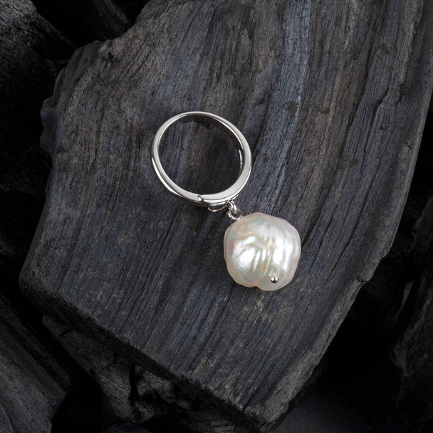 White baroque pearl pendant on black coal background - Fotografie, Obrázek