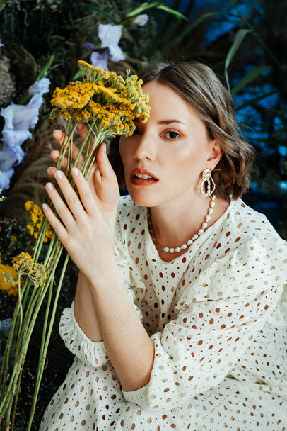 Model dziewczyna z piękną fryzurą i makijaż w białej sukience z kwiatami w stylu mody pokój dla magazynu Vogue - Zdjęcie, obraz