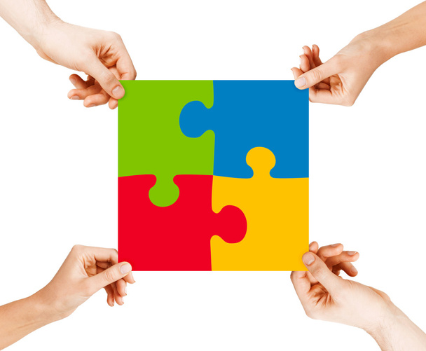 Four hands connecting puzzle pieces - Фото, изображение