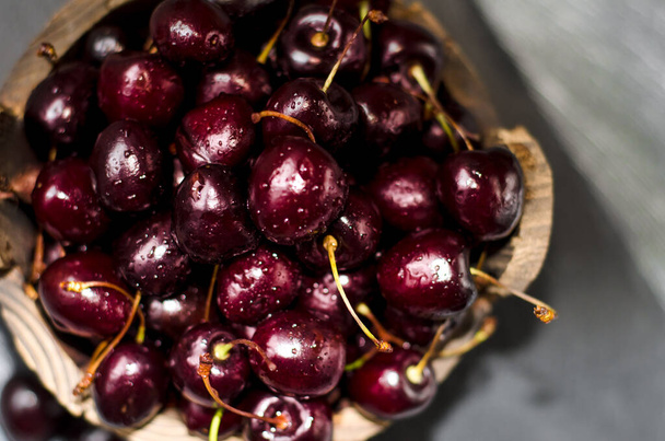 Ripe dark cherries in a wooden dish. Fruits and berries. The summer harvest. - Foto, Imagem