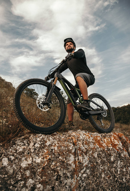 Confident male cyclist on bike in mountains - Фото, зображення