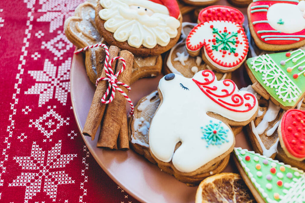 Házi készítésű karácsonyi mézeskalács sütik tányéron fából készült háttérrel. Hópihe, csillag, fa, hóember, szarvas alakzatok. Nyaralás, ünneplés és főzés koncepció. Újév és karácsonyi képeslap, közelkép. - Fotó, kép