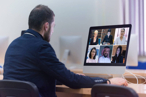 Group Using Video Conferencing technology in office for video call with colleagues abroad during coronavirus quarantine. - Photo, Image