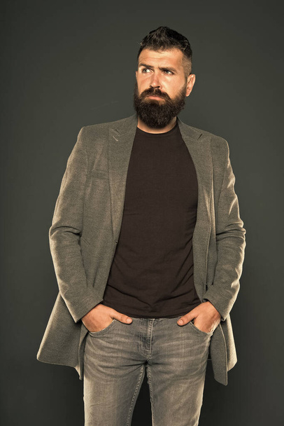 For ultimate comfort. Hipster in casual and comfy outfit keeping arms in pockets on grey background. Bearded man wear casual style. Casual and comfortable. Fashion wardrobe is casual enough - Foto, imagen