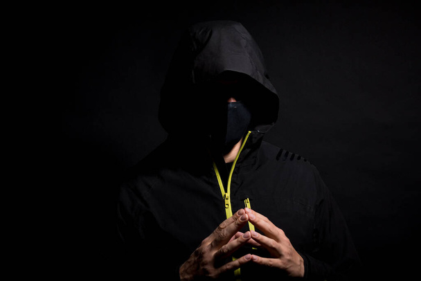 Portrait of Invisible man hacker in the hood isolated on black background. - Photo, Image