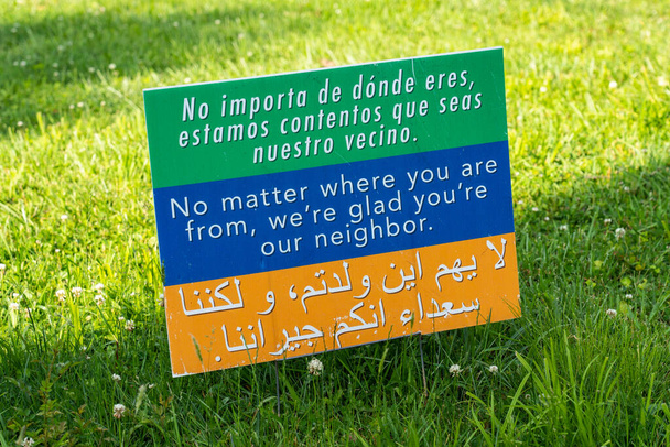 Este sinal em um gramado recebe as pessoas para o bairro em 3 idiomas, espanhol, inglês e árabe e é criativo commons tantas pessoas vão imprimi-lo e bem-vindo a todos para sua comunidade
. - Foto, Imagem