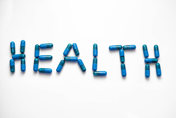 blue pills forming the word health on a white background top view - Photo, image