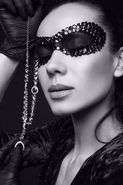 Retrato de encantadora mulher morena elegante em belo vestido roxo, lantejoulas máscara e luvas pretas posando com um colar de diamantes roubado
 - Foto, Imagem