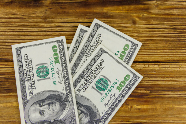Egy halom száz dolláros bankjegy a fa asztalon. - Fotó, kép