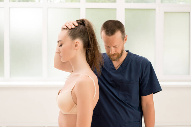Osteopath and patient in modern clinic - 写真・画像