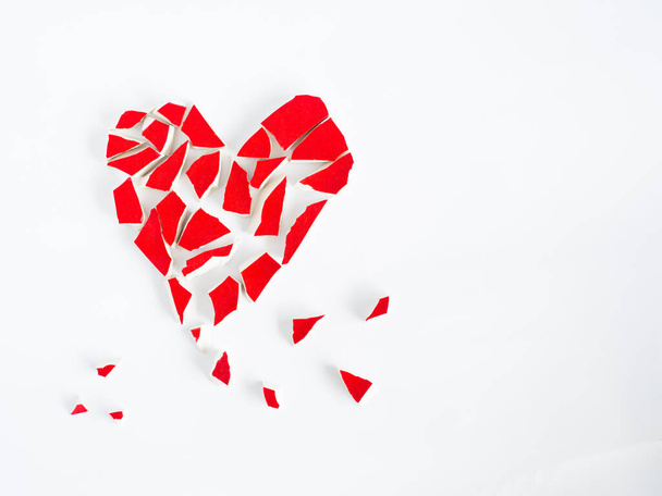Corazón roto con vidrio rojo roto en el concepto de corazón background.broken blanco. - Foto, Imagen