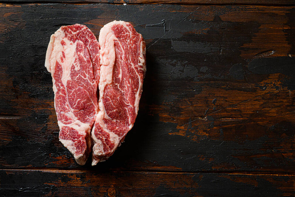 Steak de boeuf cru Chuck en forme de coeur sur table vintage en bois foncé Boeuf biologique. Vue du dessus noir. Espace pour le texte. - Photo, image