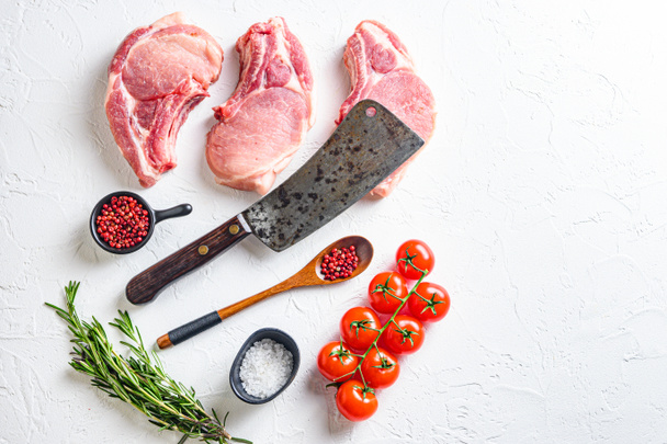 Set for  bio grilling butcher cleaver over organic bio Raw pork chops , baking or frying, textured white background. horizontal space for text - Photo, Image
