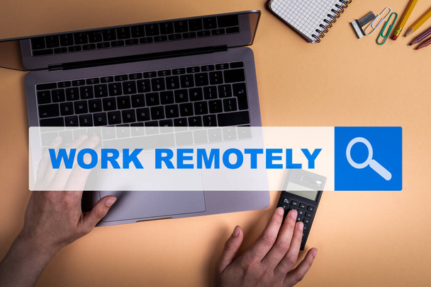 WORK REMOTELY in Verbindung setzen. Arbeiten Sie mit dem Computer von zu Hause aus. Taschenrechner und Schreibwaren - Foto, Bild