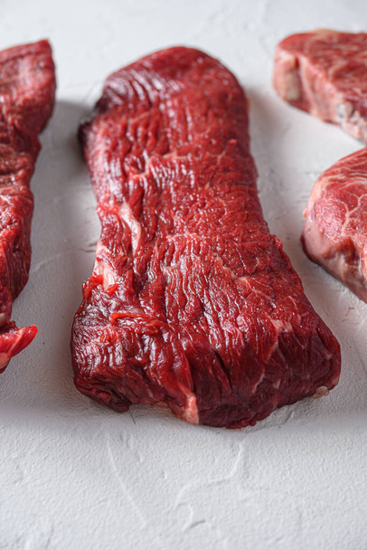 Syrové tri-tip trojúhelník pečeně nebo spodní svíčková steak řez organické maso řez boční pohled zblízka přes bílý beton pozadí vertikální selektivní zaměření. - Fotografie, Obrázek