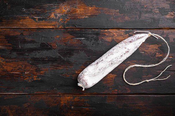 Salsicha de longaniza curada a seco na mesa de madeira velha, vista superior com espaço para texto
. - Foto, Imagem