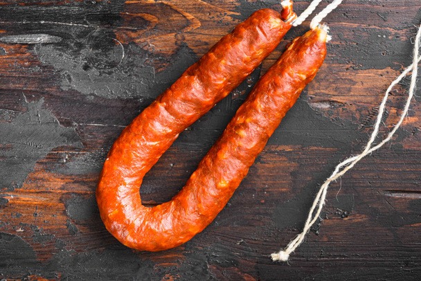 Traditional spanish chorizo sausage on old wooden table, topview. - Photo, Image