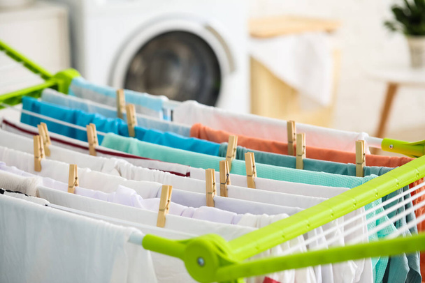 Чистая одежда висит на сушилке в прачечной, крупным планом - Фото, изображение
