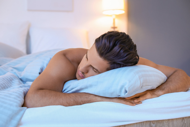 Guapo hombre desnudo durmiendo en la cama - Foto, Imagen