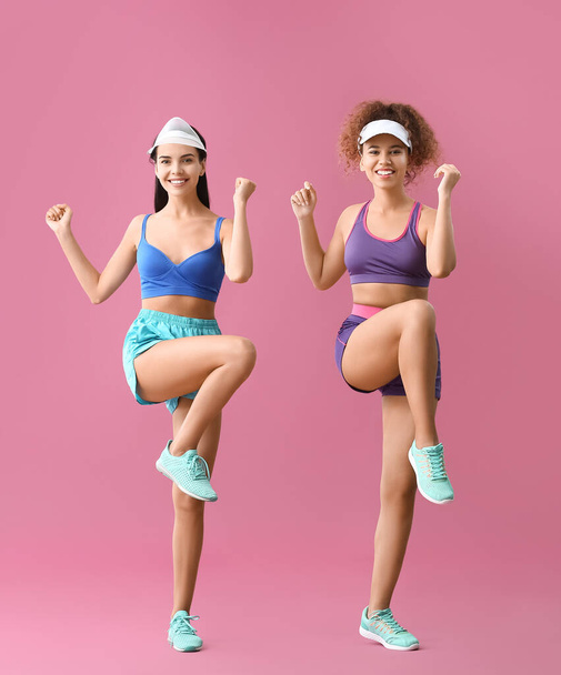 Mujeres jóvenes haciendo aeróbicos sobre fondo de color - Foto, Imagen