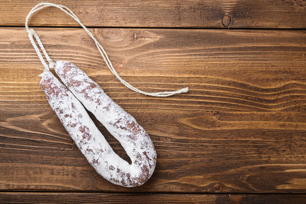 White fermented fuet sausage on light wooden background, flat lay with copy space. - Photo, Image