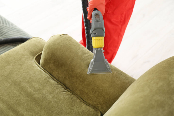 Pesulan työntekijä poistaa likaa sohvalta talossa - Valokuva, kuva
