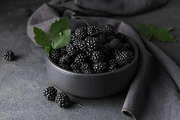 Bowl with tasty blackberry on dark background - Fotografie, Obrázek