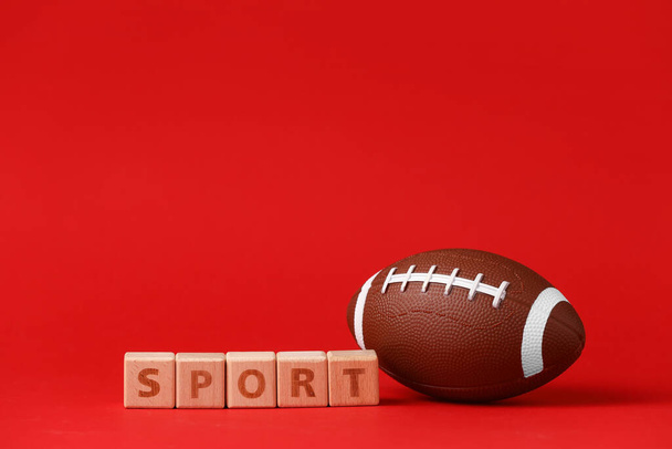 Rugby-Ball und Würfel mit Text SPORT auf farbigem Hintergrund - Foto, Bild