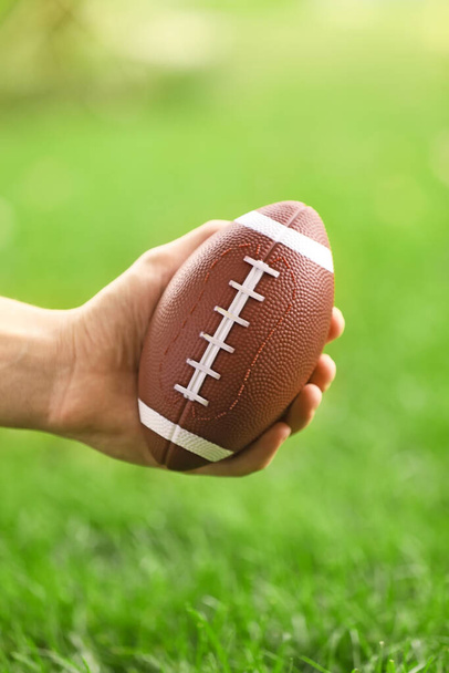 Male hand with rugby ball outdoors - Photo, Image