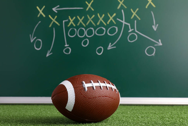 Rugby ball and scheme of football game drawn on chalkboard - Photo, Image