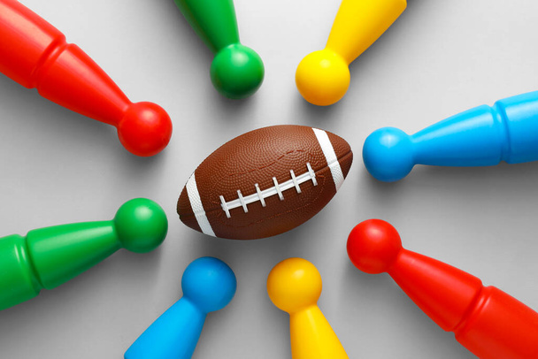 Rugby bal en bowling pinnen op grijze achtergrond - Foto, afbeelding