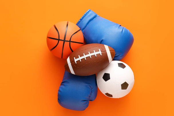 Sports balls with boxing gloves on color background - Photo, Image