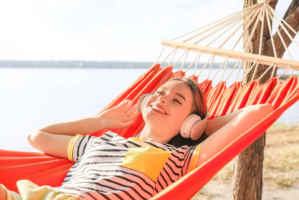 Young woman relaxing in hammock outdoors - Photo, Image