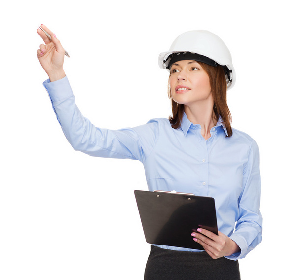 Smiling businesswoman in helmet with clipboard - Photo, image
