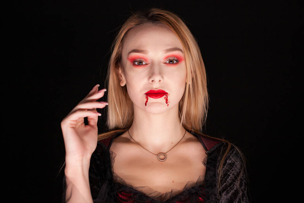 Portrait of beautiful vampire woman over black background - Photo, Image
