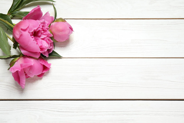 Beautiful pink peonies on white wooden background, flat lay. Space for text - Foto, immagini