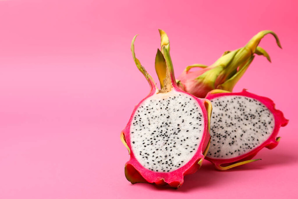 Delicious cut and whole dragon fruits (pitahaya) on pink background - Фото, зображення