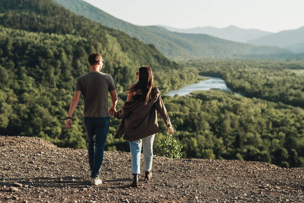 Молодая пара путешественников в путешествии, мужчина и женщина наслаждаются путешествием по красивому ландшафту - Фото, изображение