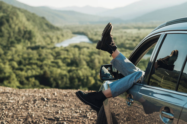 Ragazza mettere i piedi fuori dalla finestra dell'auto, giovane donna godendo viaggio - Foto, immagini