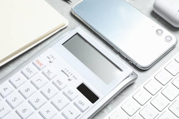 Calculator, smartphone and keyboard on grey table, closeup. Tax accounting - Photo, image