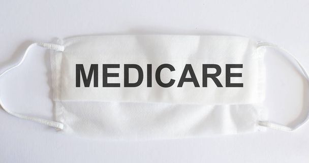 Medical mask on white background with text - MEDICARE. Medical concept - Photo, Image