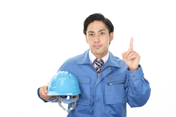 Lächelnder asiatischer Arbeiter in blauer Uniform - Foto, Bild