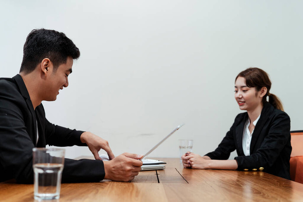 女の子を雇う前に仕事の位置についての詳細を説明するアジアのボスビジネス. - 写真・画像